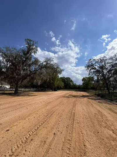 Horse arena surface being graded and compacted for consistent footing